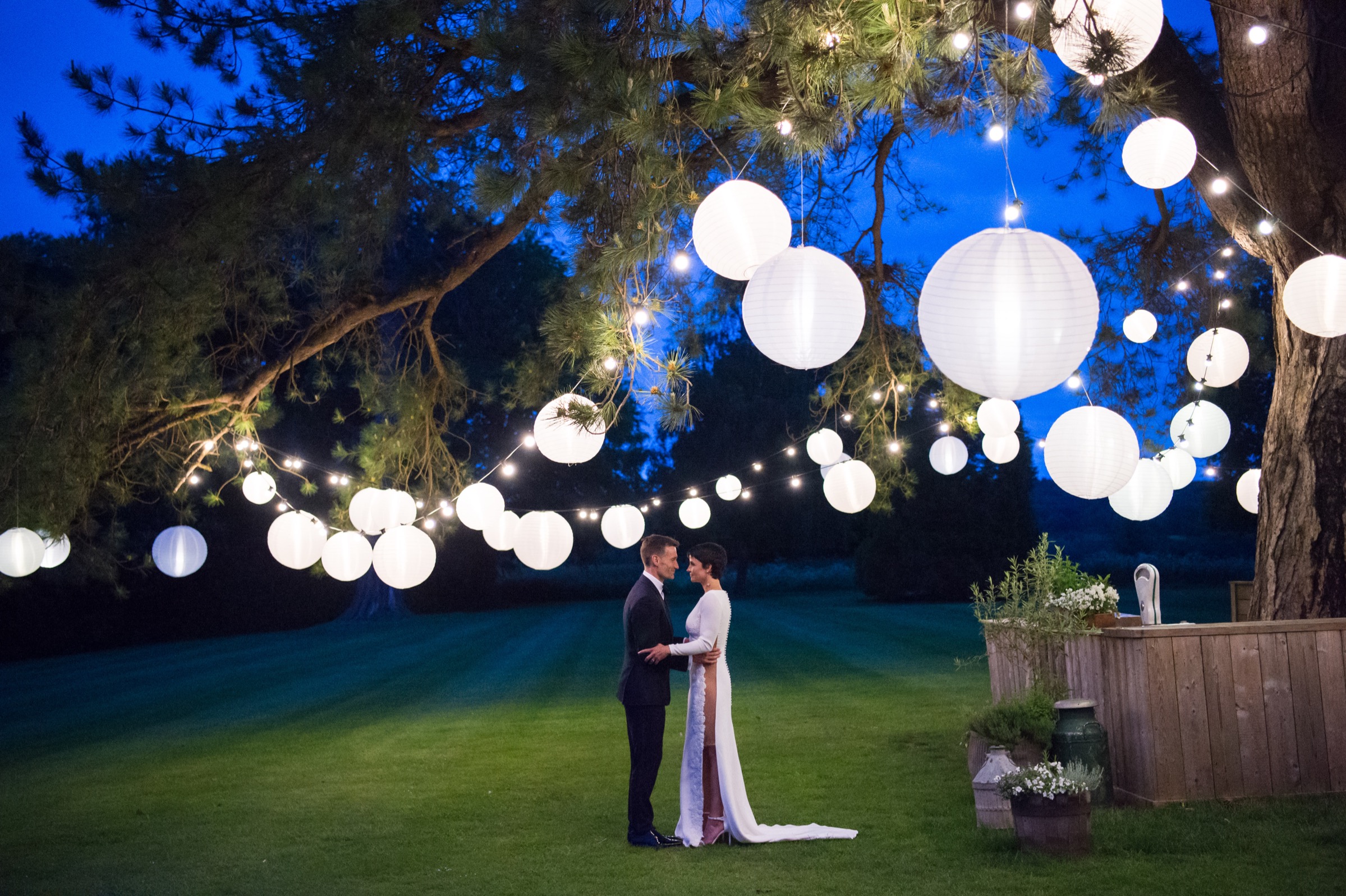 A bride and groom in the gardens of babington house at nighttime